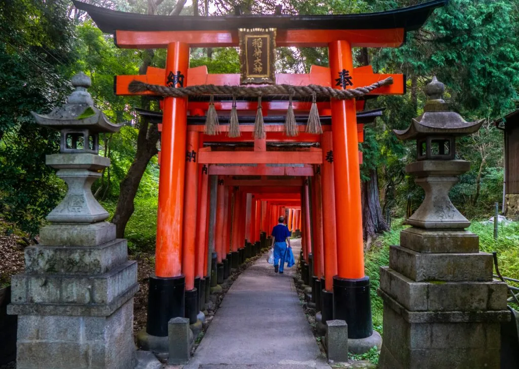 Turistas em fila nos torii vermelhos de Fushimi Inari em Kyoto, exemplo do overtourism no Japão