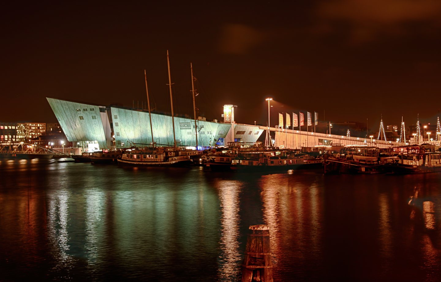 Fachada do NEMO Science Museum iluminada à noite em Amsterdã.